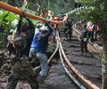 Thai rescue workers positioning a pipe for the pumping operation in the Tham Luang cave