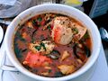 A bowl of cioppino with seafood and tomato broth.